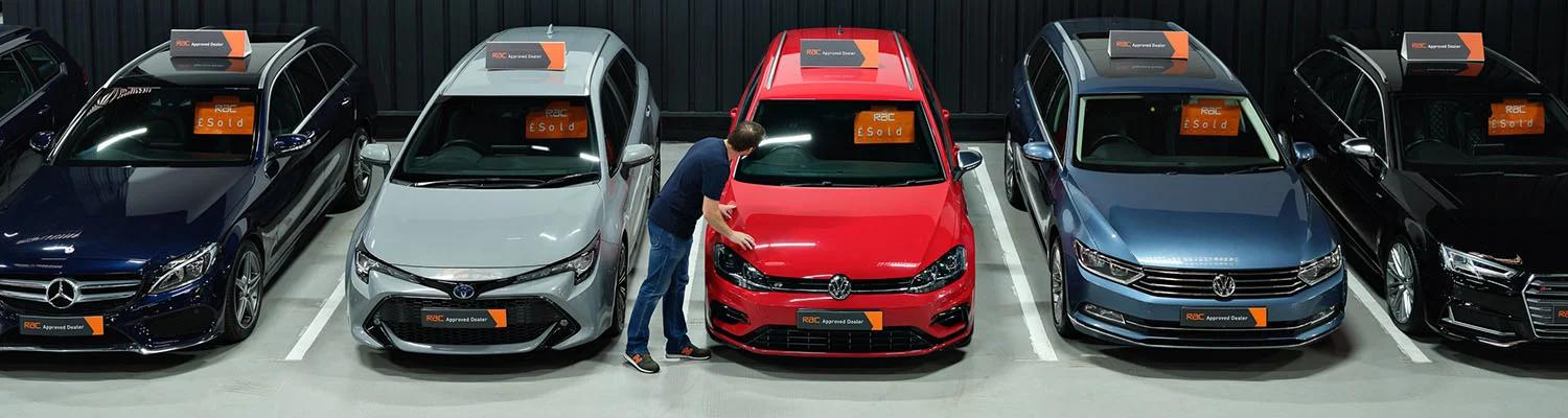 Man looking into a car in a car showroom