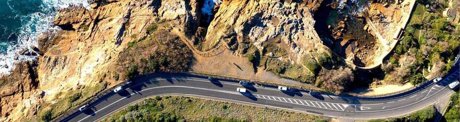 Road with cars on it with the sea in the background